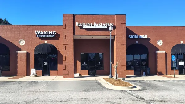 Brick storefronts with signs for Beltline Bariatric, Waxing by Maria, and Skin Bar under a clear blue sky.