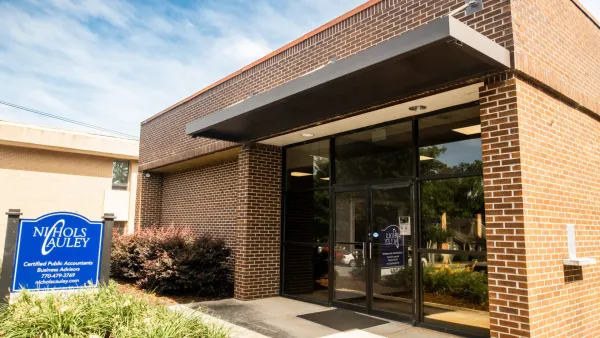 Entrance of Nichols Cauley Certified Public Accountants office with brick exterior and blue signage.