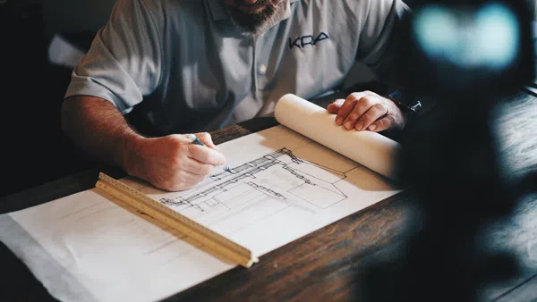 a man drawing up a construction plan
