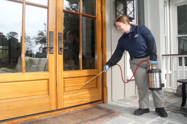 pest control professional applying products at front door