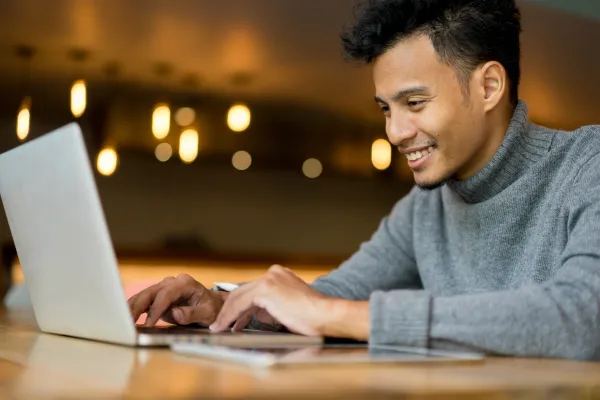 a man sitting at a table using a laptop