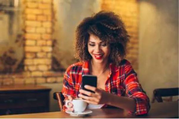 woman enjoying coffee and using cell phone