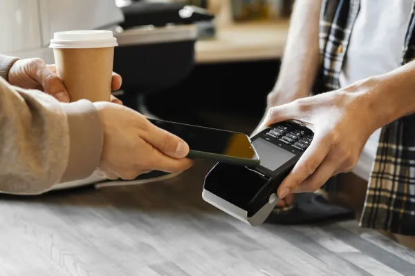 a person using a phone to pay for coffee