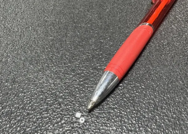 a pen and pills on a carpet