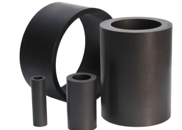 Four black cylindrical rubber sleeves or bushings of varying sizes arranged on a white background