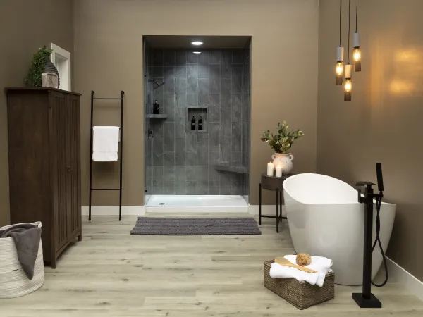 Modern bathroom with freestanding tub, walk-in shower, wooden cabinet, and pendant lights