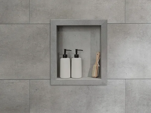 Built-in bathroom niche with two soap dispensers and a wooden brush on gray tile wall.