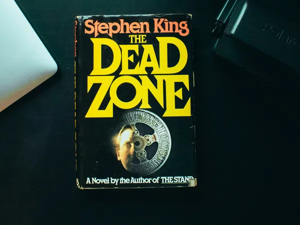 Stephen King’s novel The Dead Zone with overlaid title text in yellow on a black book cover.