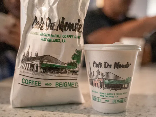 Cafe Du Monde coffee cup and bag featuring French Market coffee shop branding from New Orleans, Louisiana.