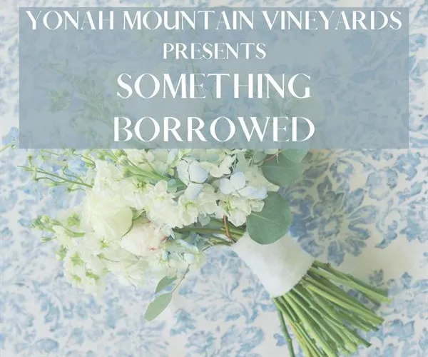 White bridal bouquet on blue floral fabric with Yonah Mountain Vineyards Something Borrowed text overlay.