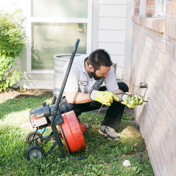a man cleaning a drain line