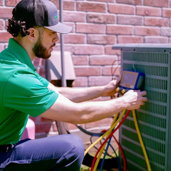 ac technician working on air conditioning unit in Greenville, Texas