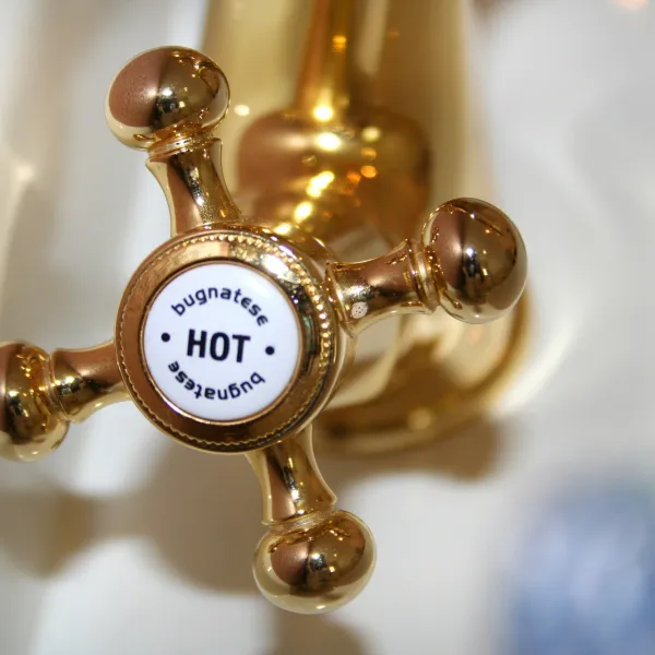 a close up of a gold hot water facuet