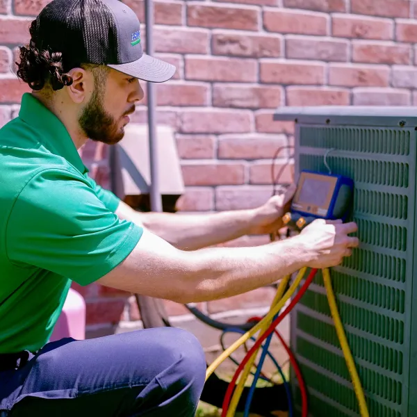 ac technician working on air conditioning unit