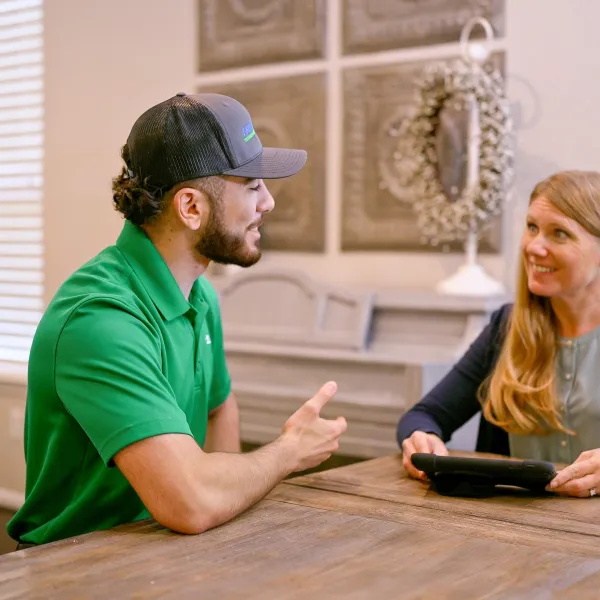 A Houston AC technician discusses thermostat options with a homeowner