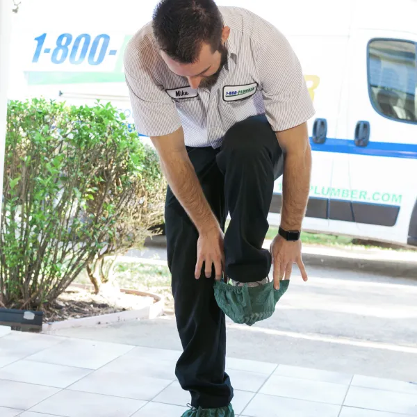 a plumber putting on shoe covers