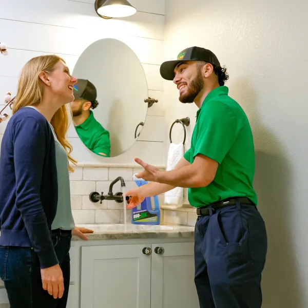 A houston plumber and a woman stand by a sink