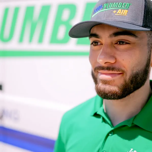 a plumber standing next to a van