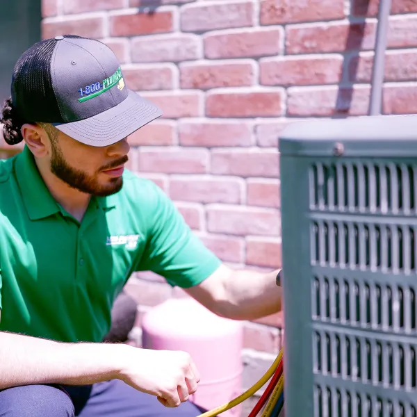 ac technician working on air conditioning unit