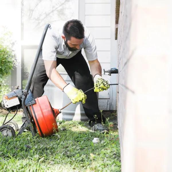 1-800-PLUMBER +AIR technician cleaning a drain