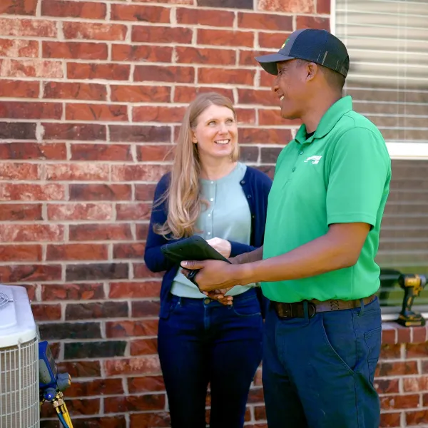 a man and a woman standing in front of a brick building