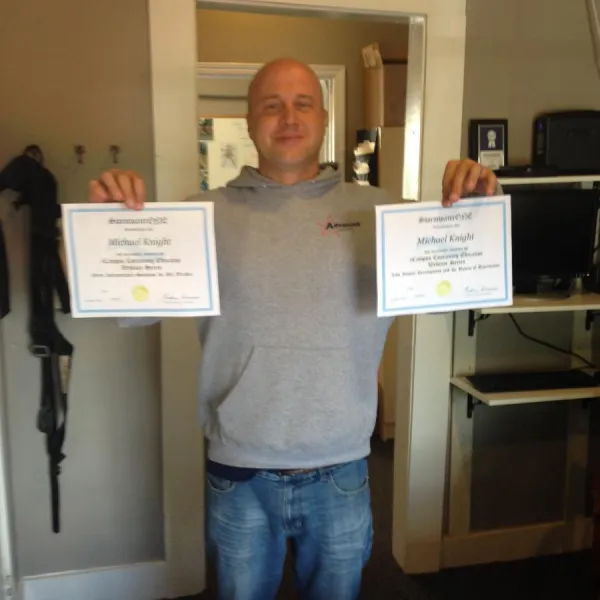 an employee holding two diplomas