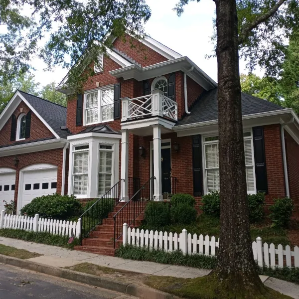 a red house with a white picket fence and a white picket fence