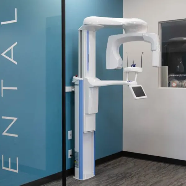 Modern dental panoramic X-ray machine inside a clean dental clinic with blue and white walls