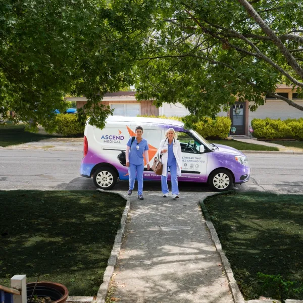 a couple of people standing next to a purple car