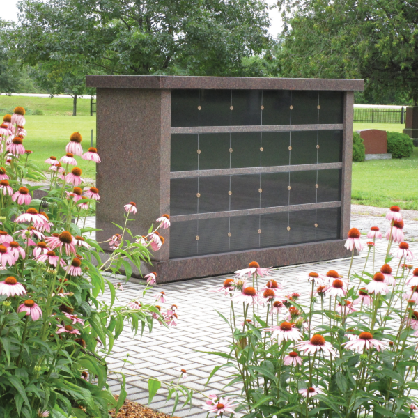 a gravestone with flowers in front of it