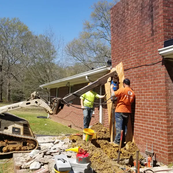a few men working on a brick building