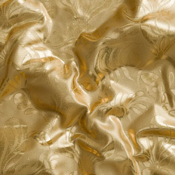 Shiny gold satin fabric with floral embossed pattern and smooth folds reflecting light elegantly