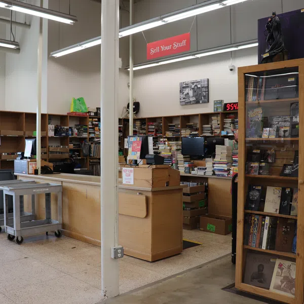 Interior of a bookstore with shelves full of books, a Sell Your Stuff counter, and Gifts & Stationery section.