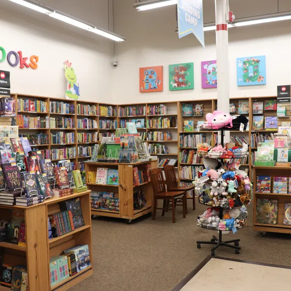 Children's section of a bookstore with colorful books, plush toys, and kid-friendly decorations