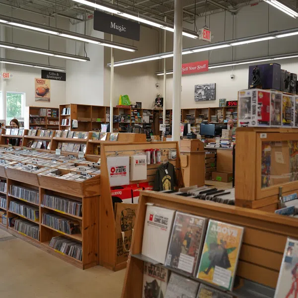 Interior view of a well-organized music and media store with wooden shelves and various CDs and collectibles.