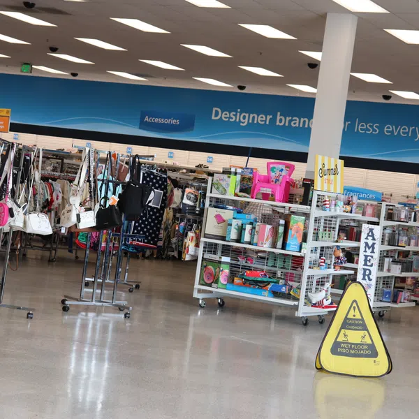 Interior of store with clothing racks, handbags, and shelves of beauty and accessory products on display