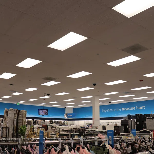 Interior of a large retail store with racks of clothing, home goods, and bright ceiling lights.