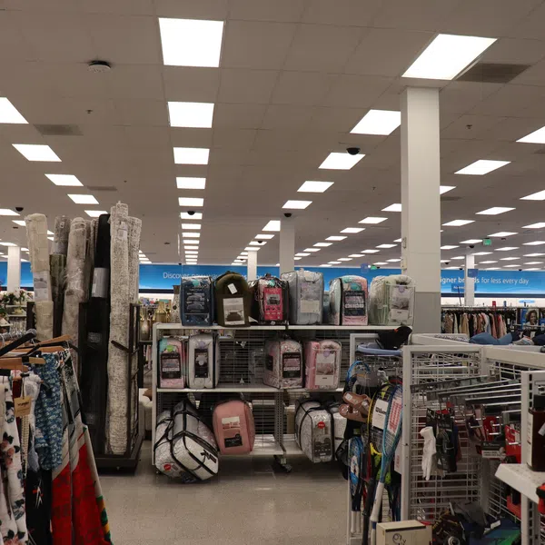 Interior of a large retail store with bedding, home goods, and clothing aisles under bright fluorescent lights.