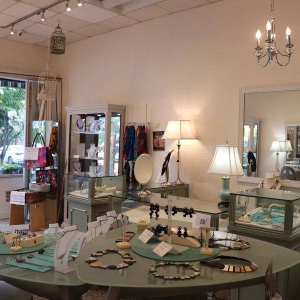 Bright boutique jewelry store interior with necklaces, earrings, display cases, and table lamps