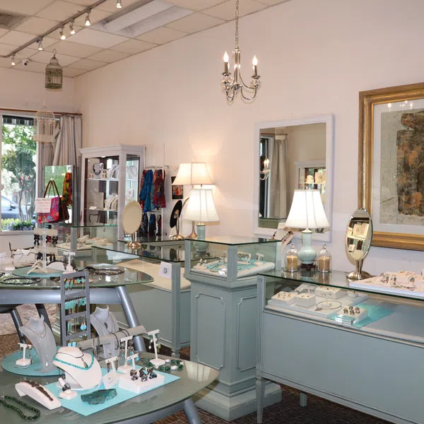 Interior of a bright jewelry store with glass display cases showcasing rings, necklaces, and bracelets.