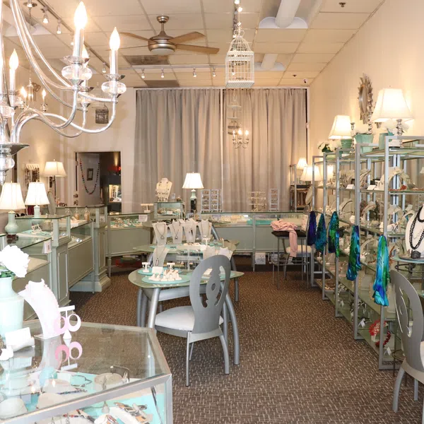 Bright and elegant jewelry store interior with glass display cases, chandeliers, and stylish seating