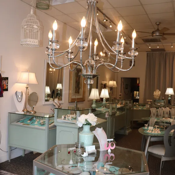 Interior of an elegant jewelry store with glass display cases, chandelier lighting, and various jewelry pieces.