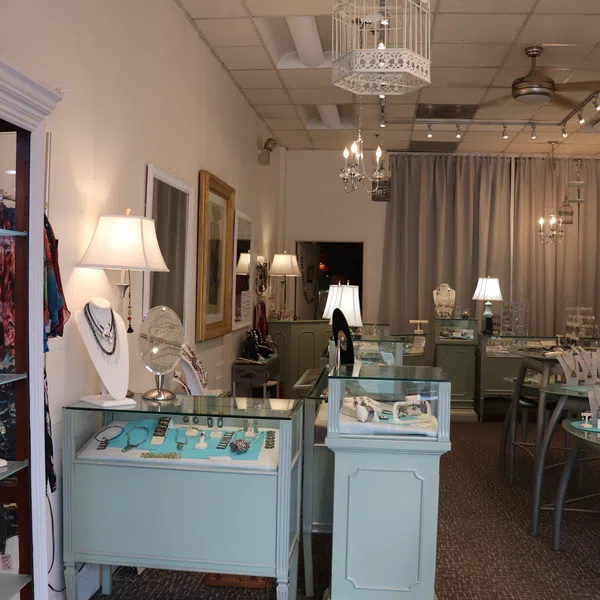 Elegant jewelry store interior with glass display cases, soft lighting, and decorative birdcage chandeliers.