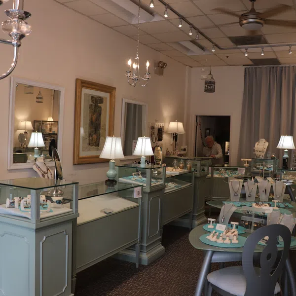 Interior of a jewelry store with glass display cases, elegant lighting, and various jewelry pieces on display.