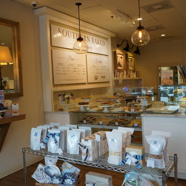 Cozy bakery interior with display cases of pies, packaged goods, warm lighting, and Southern Baked signage