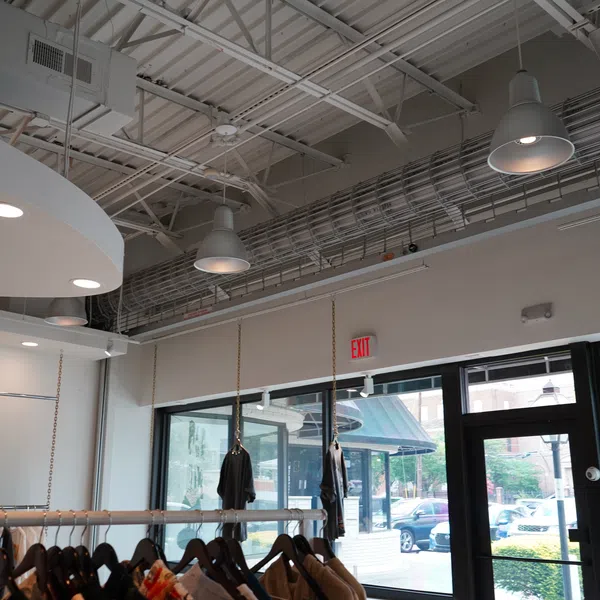 Modern clothing store interior with black shirts hanging on racks and natural light from large windows