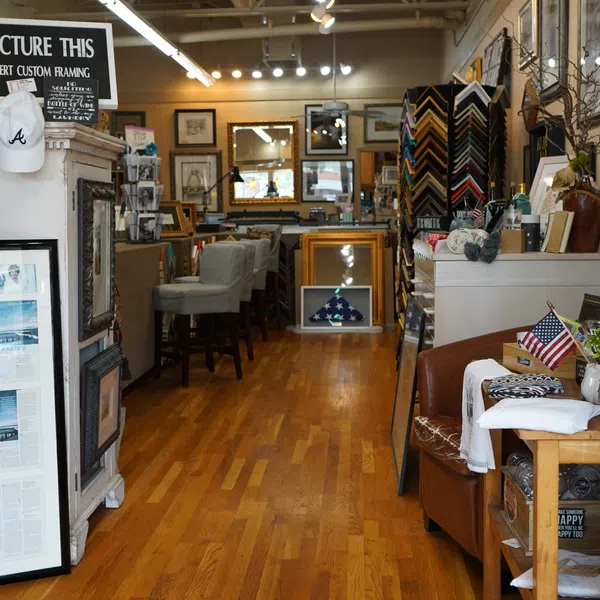 Interior view of a custom framing shop with picture frames, art, and memorabilia on display