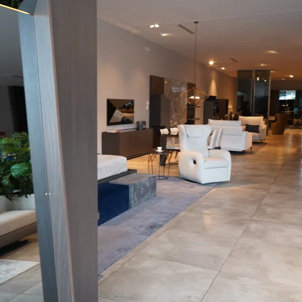 Modern furniture showroom with armchairs, sofas, and stylish décor in a spacious, well-lit interior.