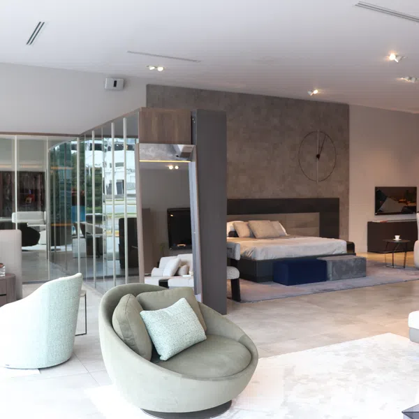 Modern open-concept living space with stylish seating, bed area, and minimalist decor in neutral tones.