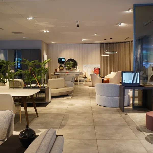 Modern lounge area with comfortable seating, circular tables, indoor plants, and warm ambient lighting.